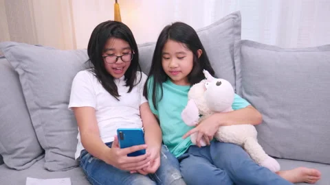 Happy siblings children sitting on sofa in living room speak with parent on m Stock Footage 158592133