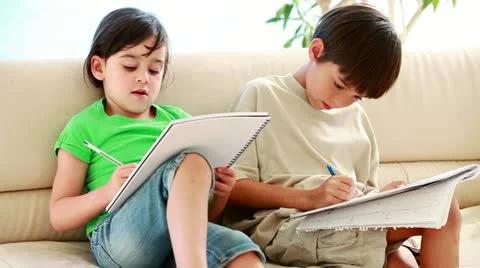 Happy siblings doing their homework Stock Footage