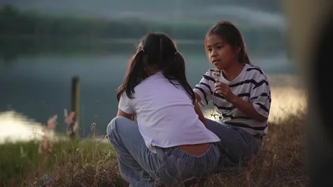 Happy Siblings Sharing a Peaceful Moment by the Lake at Sunset. Stock Footage 327248564