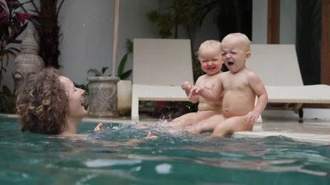 Happy single parenthood. Young mom playing with her twin babies at the private Video stock 146785015