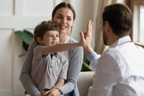 Happy small boy greeting with male doctor in hospital Stock Photos