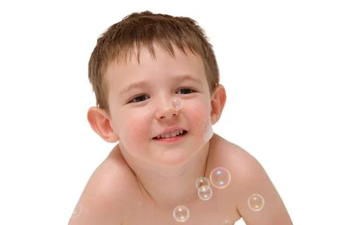 Happy small boy playing with soap bubbles on isolated white background. Child Stock Photos