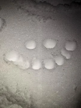 Happy Smiley Face Pattern Drawn in Clean White Snow at Night Fotos Stock
