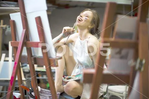 Happy smiling artist woman painting on canvas with acrylic colors. Young love Stock Photos