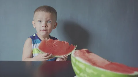 Happy smiling boy appetizing eating red watermelon and juice flowing under the Video stock 114488194