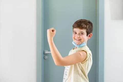 Happy smiling boy looking at camera showing proud vaccinated arm. Stock Photos