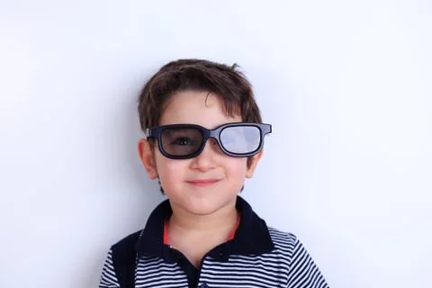 Happy smiling boy looking through sunglasses, studio shoot on wh Stock Photos