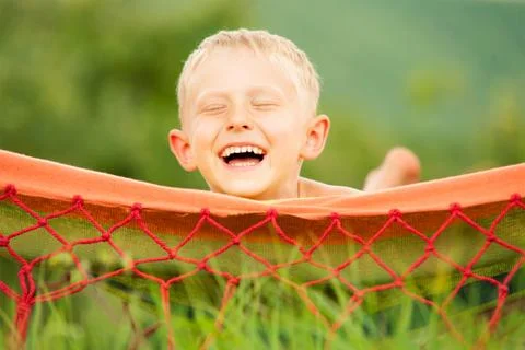 Happy smiling boy lying in hammock Foto stock