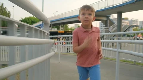 Happy smiling boy running around the city in the summer. Holidays, hooray. Stock Footage 264480948