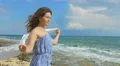 Happy smiling brunette holding white scarf in the wind. Sunny day at seashore 4k or 4k+ Resolution