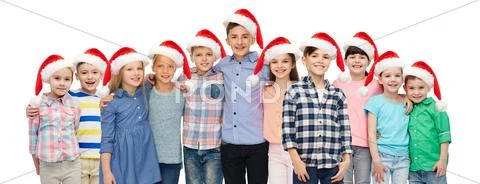 Happy smiling children in santa hats hugging Stock Photos