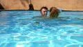 Happy Smiling Couple Bathing Together in Pool. Slow Motion. HD Footage