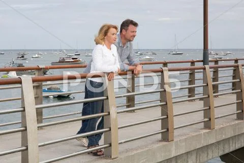 Happy smiling couple in love on the bridge Stock Photos