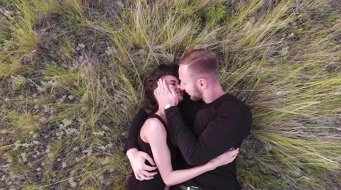 Happy smiling couple lying on grass and relaxing.Shooting from the air Stock Footage 65401582