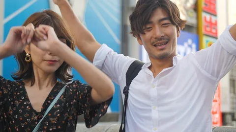 Happy smiling couple posing infront of Osaka Icon landmark tourist experience Vidéo 111353505