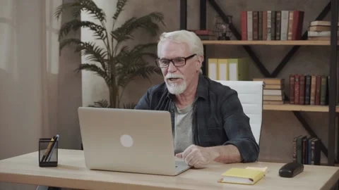 Happy smiling elderly man talking on webcam in video chat and waving hand hello Stock Footage 151893042