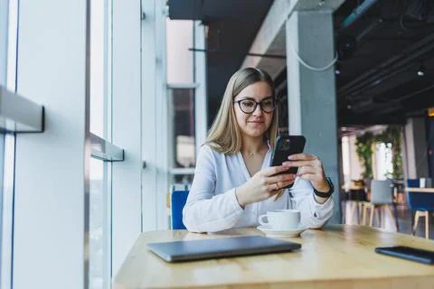 Happy smiling female manager using mobile phone gadget to check delivery serv Stock Photos