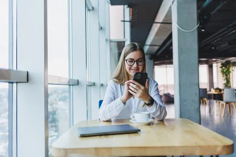 Happy smiling female manager using mobile phone gadget to check delivery serv Stock Photos