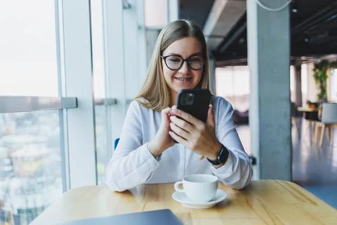 Happy smiling female manager using mobile phone gadget to check delivery serv Stock Photos