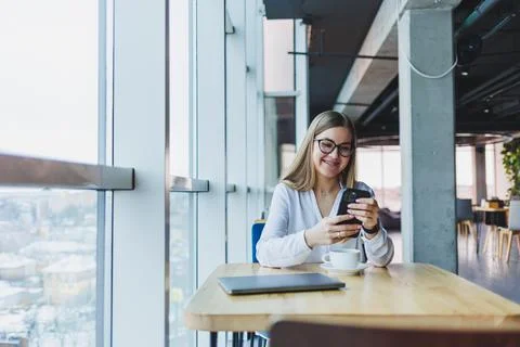 Happy smiling female manager using mobile phone gadget to check delivery serv Stock Photos