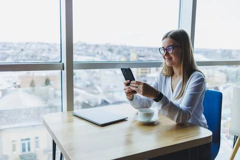 Happy smiling female manager using mobile phone gadget to check delivery serv Stock Photos