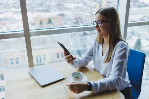 Happy smiling female manager using mobile phone gadget to check delivery serv Stock Photos