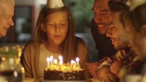 Happy Smiling Girl Blowing Candles out on her Birthday Cake.  Stock Footage