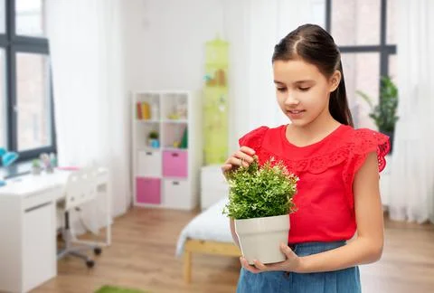 Happy smiling girl holding flower in pot Stock Photos