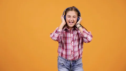 Happy smiling girl jumping while listening music Stock Footage 97638874