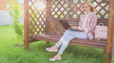 Happy Smiling Girl Using Notebook Sitting on a Bench 1 Stock Footage 65242321