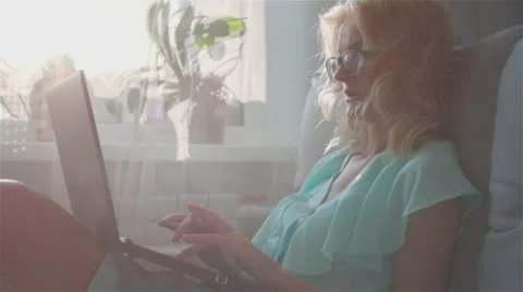 Happy Smiling Girl Using Notebook Sitting on Sofa at Home 1 Stock Footage 65749853