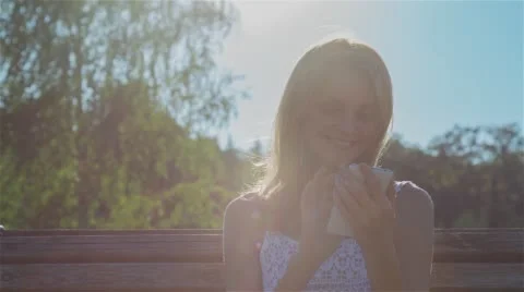 Happy Smiling Girl Using SmartPhone in City Park Sitting on the Bench Stock Footage 67354589