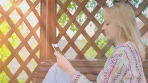 Happy smiling girl using Tablet PC sitting on a bench 1 Video stock 65242793