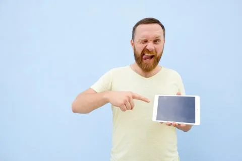 Happy smiling Handsome young man with a beard showing something on a tablet i Stock Photos