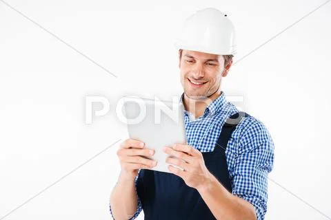 Happy smiling male builder using pc tablet Stock Photos