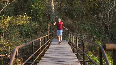 Happy smiling man with backpack dancing, celebrating he finished hard trekking Stock Footage 197468629