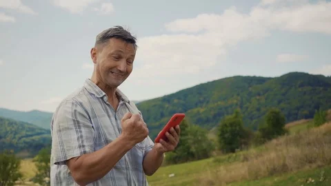 Happy smiling man in the mountains use phone technology a concept of connection Stock Footage 116997682