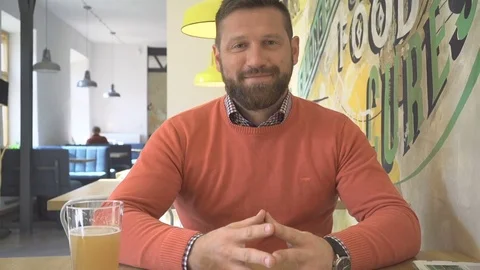 Happy, smiling man points the finger at camera, portrait, in cafe, steadicam Vídeo Stock 73230149