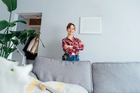 Happy smiling proud of herself young brunette woman in plaid shirt after she put Stock Photos