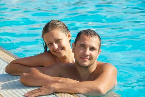 Happy smiling  while relaxing on the edge of a swimmingpool Foto stock