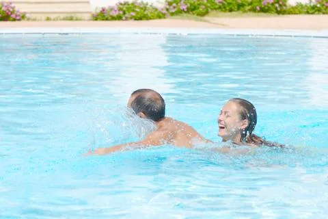 Happy smiling  while relaxing on the edge of a swimmingpool Stock Photos