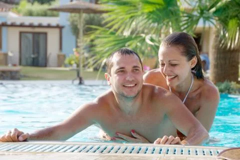 Happy smiling  while relaxing on the edge of a swimmingpool Stock Photos
