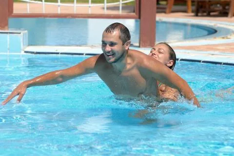 Happy smiling  while relaxing on the edge of a swimmingpool Foto stock