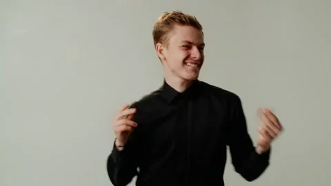 A happy smiling winsome guy is dancing joyfully with energetic fervor. A young Stock Footage 253627867