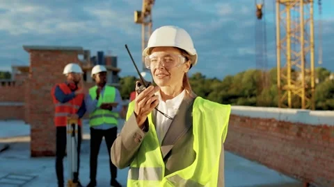 Happy smiling woman builder engineer worker in hard hat with use a walkie-talkie Stock Footage 139341981