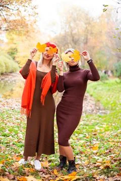 Happy smiling womans holding in her hands yellow maple leaves Stock Photos