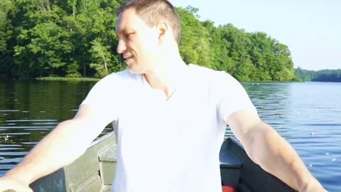 Happy smiling young man rowing boat on lake in Virginia during summer Stock Footage 80206419