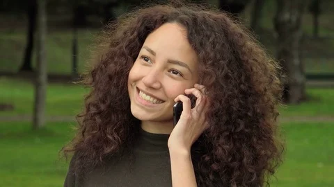 Happy smiling young woman using cell phone to have a phone call Video stock 75553192