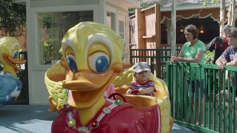 Happy smilling boy is riding a duck at an amusement park 4k Stock Footage