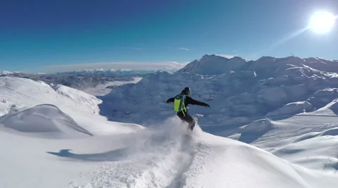 Happy snowboarder having fun riding powder snow off piste in snowy mountains Stock Footage